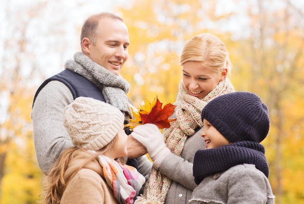 Concetto della famiglia, dell'infanzia, di stagione e della gente - famiglia felice nel parco di autunno