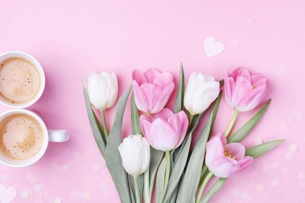 Concetto della festa della donna 8 marzo Caffè mattutino e fiori di tulipano primaverile su sfondo rosa pastello Piatto l