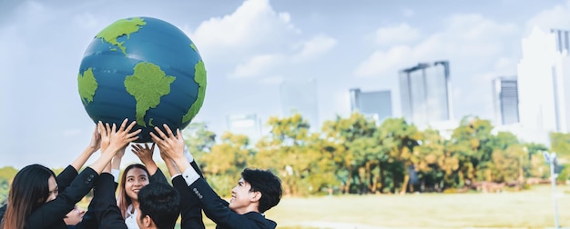 Concetto della Giornata della Terra con un grande globo terrestre tenuto da un gruppo di uomini d'affari asiatici che promuovono la consapevolezza ambientale con la sostenibilità ambientale e il principio ESG per un futuro più luminoso Gyre