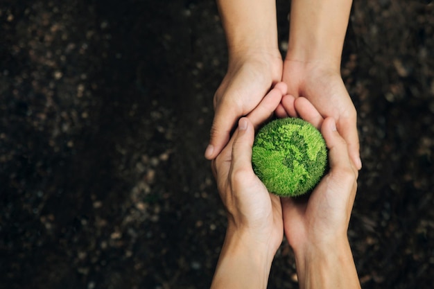 Concetto della Giornata Mondiale della Terra Mani di persone che abbracciano la terra verde G