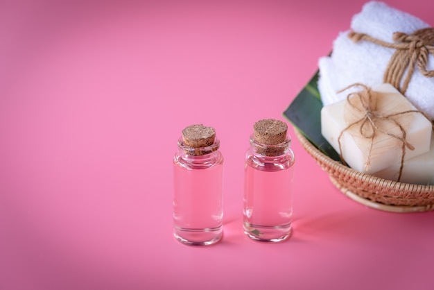 Concetto della stazione termale, bottiglia liquida della rosa, sapone del latte, tovaglioli bianchi in vassoio di legno