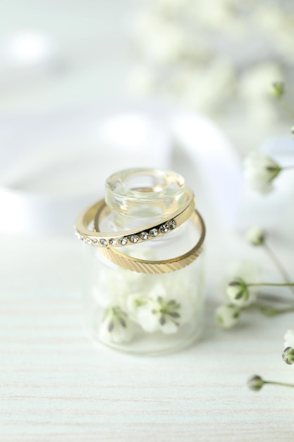 Concetto di accessori da sposa con fedi nuziali su fondo di legno bianco