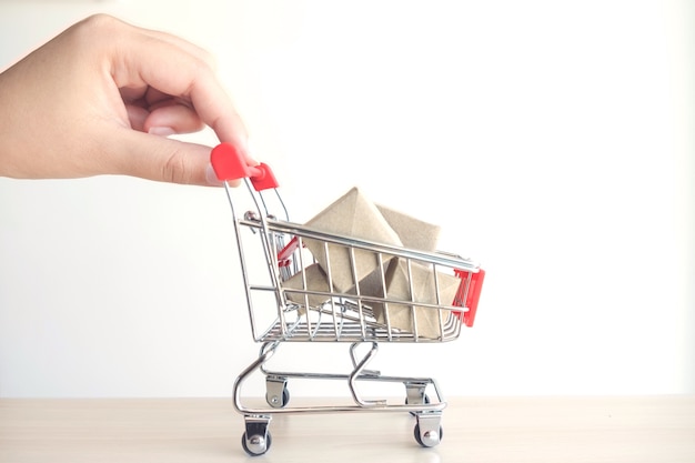 concetto di acquistare shopping, mano di donna che spinge Carrello rosso pieno di scatola di regali