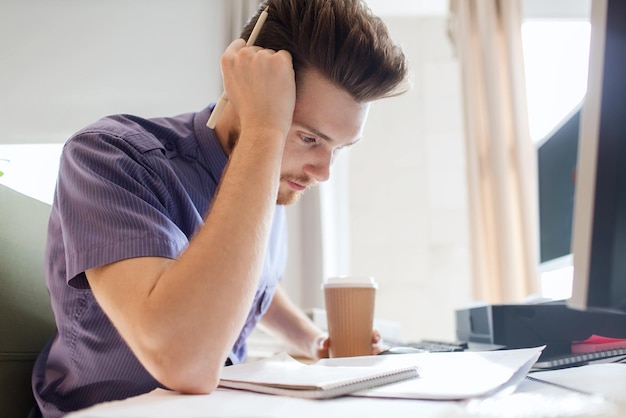 concetto di affari, avvio e persone - uomo d'affari o impiegato maschio creativo che beve caffè e pensa