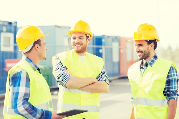 concetto di affari, costruzione, lavoro di squadra, tecnologia e persone - gruppo di costruttori sorridenti in elmetti protettivi con computer tablet pc all'aperto