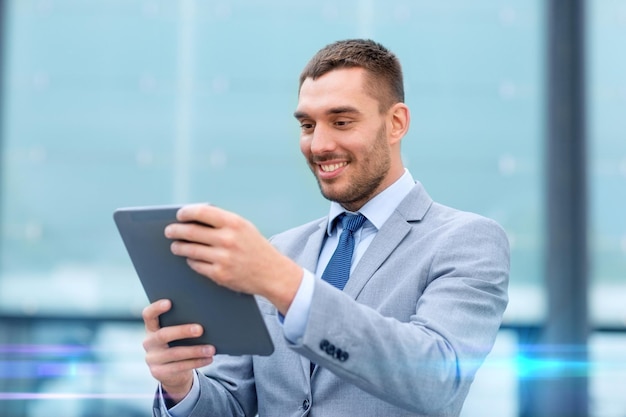 concetto di affari, istruzione, tecnologia e persone - uomo d'affari sorridente che lavora con il computer tablet pc sulla strada della città