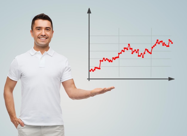 concetto di affari, statistica, economia, successo e persone - uomo sorridente che mostra un grafico in crescita su sfondo grigio