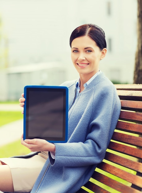 concetto di affari, tecnologia e persone - giovane donna sorridente con computer tablet pc seduto su una panchina in città