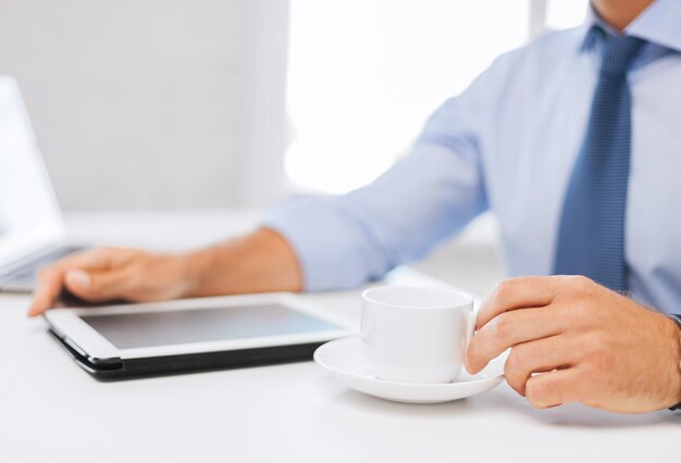 concetto di affari, ufficio, scuola e istruzione - uomo d'affari con tablet pc che beve caffè in ufficio