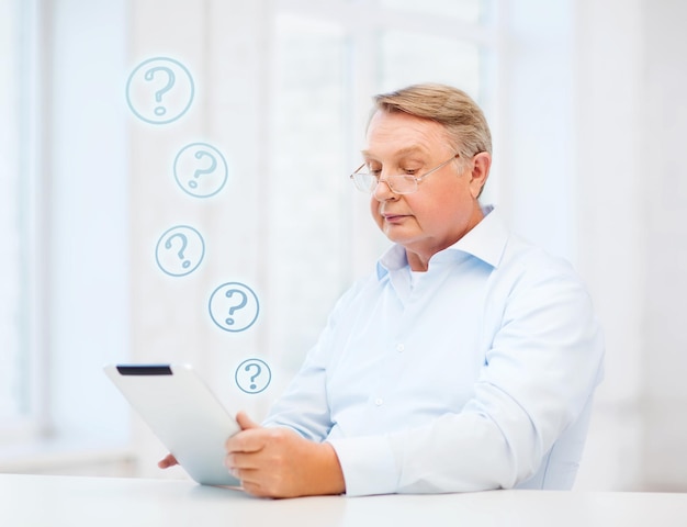 concetto di affari, ufficio, vecchiaia, scuola e istruzione - uomo anziano che indossa occhiali da vista con computer tablet a casa