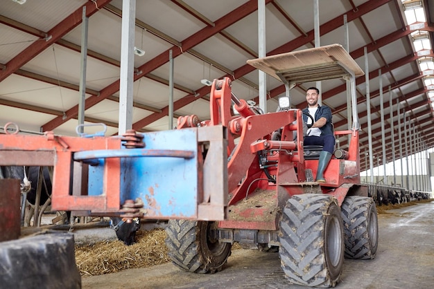 concetto di agricoltura, agricoltura e persone - giovane felice o contadino che guida un trattore in fattoria