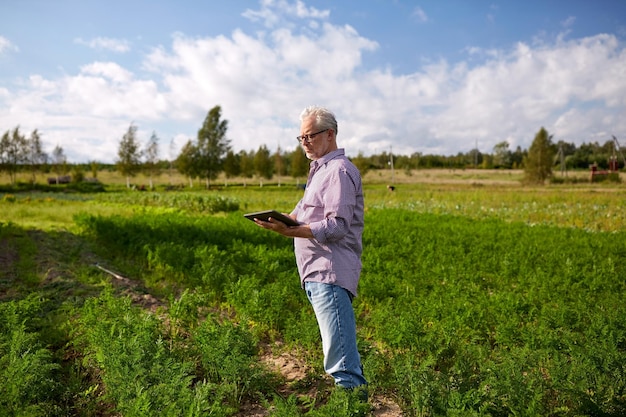 concetto di agricoltura, agricoltura, tecnologia e persone - uomo anziano con computer tablet pc in contea o fattoria