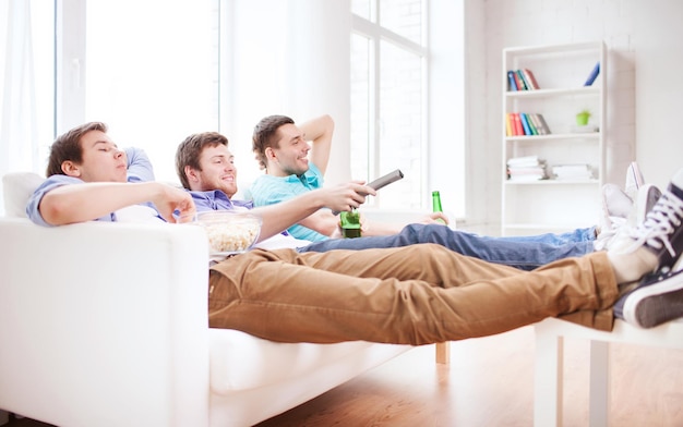 concetto di amicizia, casa, sport e intrattenimento - amici maschi felici con birra che guardano la tv a casa
