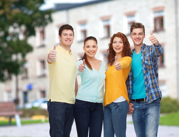 concetto di amicizia, istruzione, vacanze estive e persone - gruppo di adolescenti sorridenti che mostrano i pollici in su sullo sfondo del campus