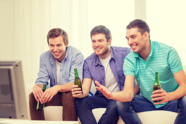 concetto di amicizia, sport e intrattenimento - amici maschi felici con birra che guardano la tv a casa