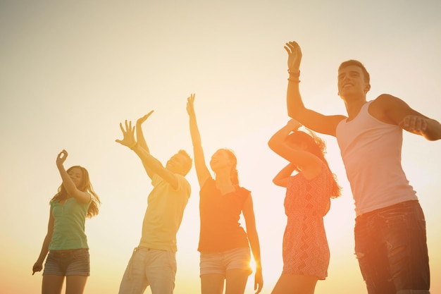 concetto di amicizia, vacanze estive, vacanze, feste e persone - gruppo di amici sorridenti che ballano sulla spiaggia