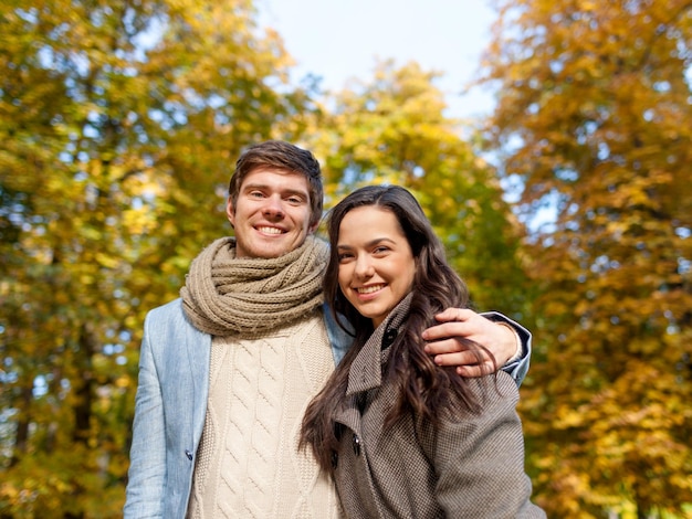 Concetto di amore, di relazione, della famiglia e della gente - le coppie sorridenti che abbracciano in autunno parcheggiano