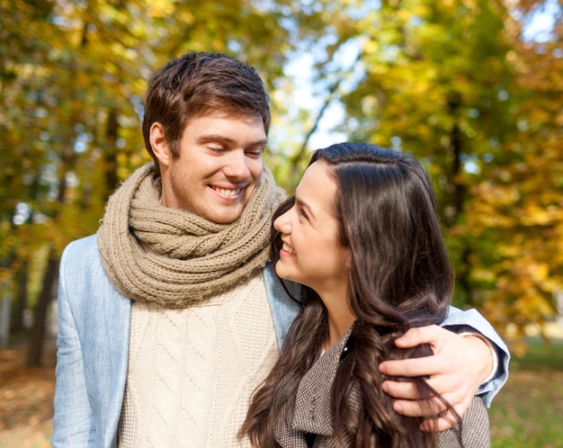 Concetto di amore, di relazione, della famiglia e della gente - le coppie sorridenti che abbracciano in autunno parcheggiano