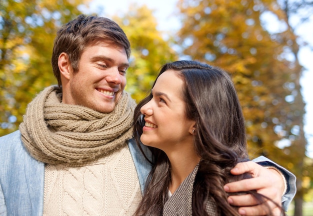 Concetto di amore, di relazione, della famiglia e della gente - le coppie sorridenti che abbracciano in autunno parcheggiano