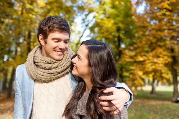 Concetto di amore, di relazione, della famiglia e della gente - le coppie sorridenti che abbracciano in autunno parcheggiano