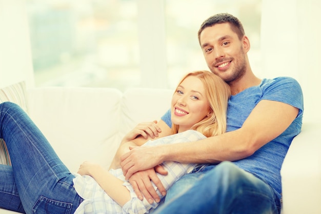 concetto di amore, famiglia e felicità - coppia felice sorridente a casa