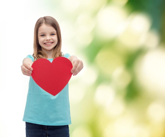 concetto di amore, felicità e persone - bambina sorridente che dà cuore rosso