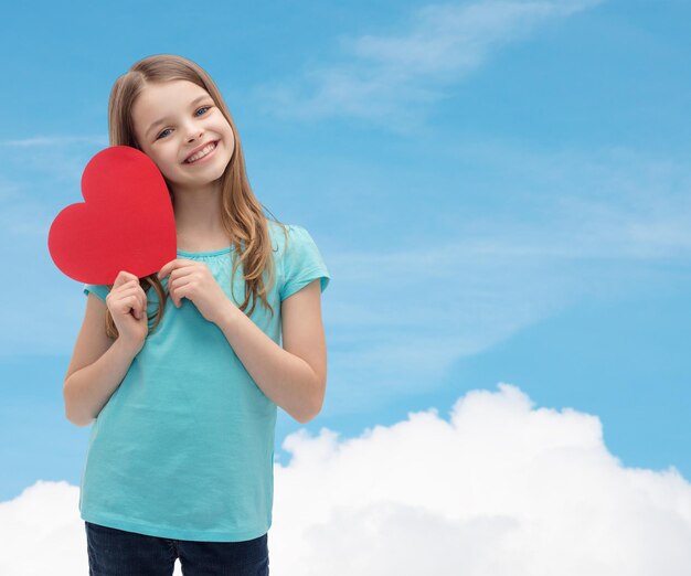 concetto di amore, felicità e persone - bambina sorridente con cuore rosso