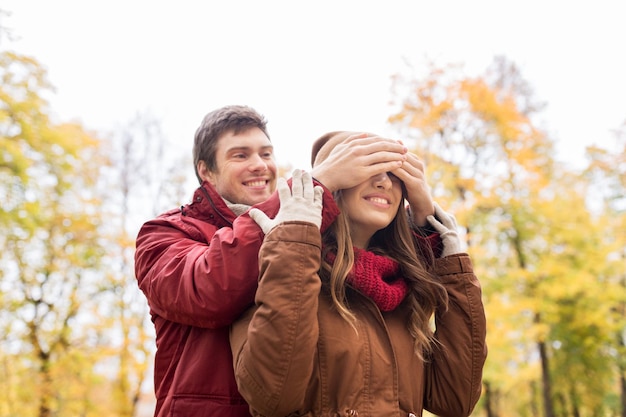 concetto di amore, relazioni, stagione e persone - giovane coppia felice che si diverte nel parco autunnale