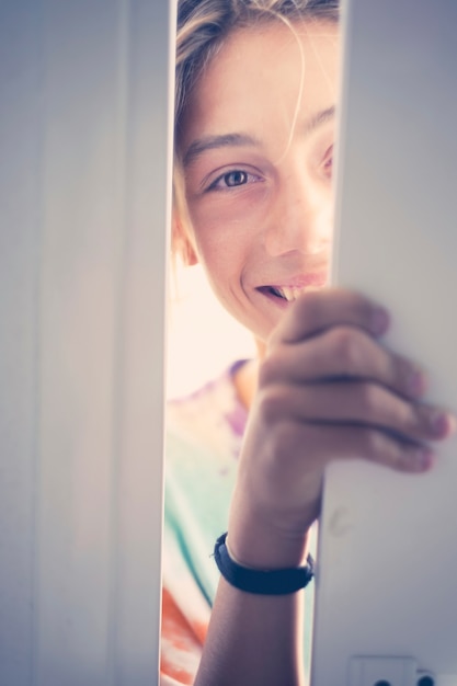 concetto di apertura della porta con una bella bionda caucasica adolescente che entra nella porta di casa come un ospite