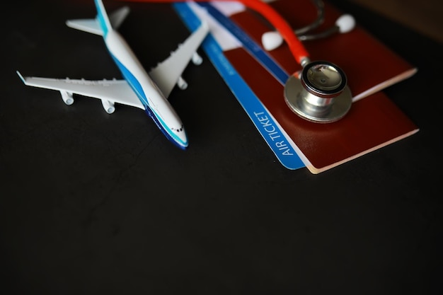 Concetto di assicurazione aerea per i passeggeri Carta d'imbarco e stetoscopio per il passaporto dell'aeroplano