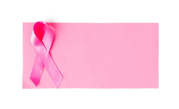 concetto di assistenza sanitaria, carità, simbolica, oncologia e medicina - primo piano del nastro rosa per la consapevolezza del cancro su un foglio di carta bianco
