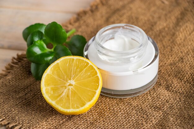 concetto di assistenza sanitaria. Cosmetici biologici al limone. Idratante naturale su fondo in legno.