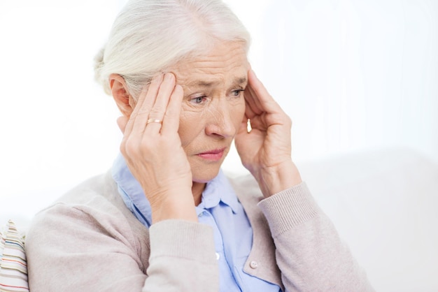 concetto di assistenza sanitaria, dolore, stress, età e persone - volto di donna anziana che soffre di mal di testa