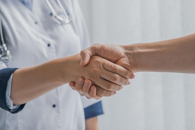 Concetto di assistenza sanitaria e assistenza Primo piano del medico e del paziente che si stringono la mano