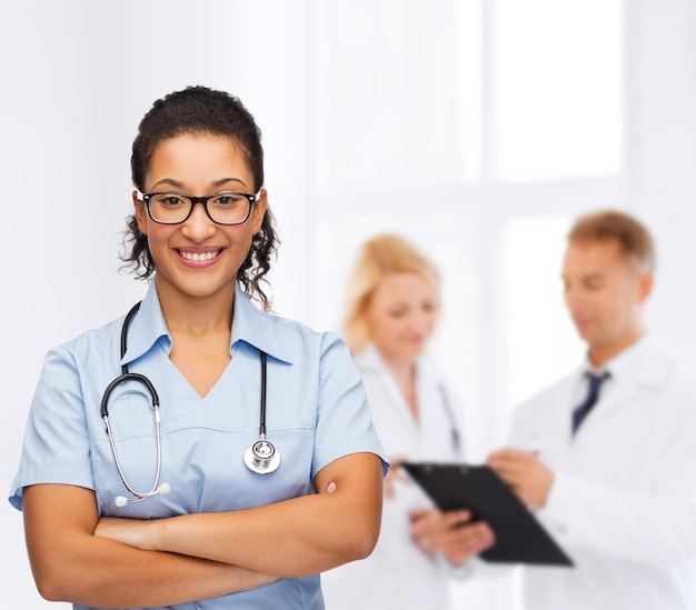 concetto di assistenza sanitaria e medicina - medico o infermiere afroamericano sorridente in occhiali con stetoscopio