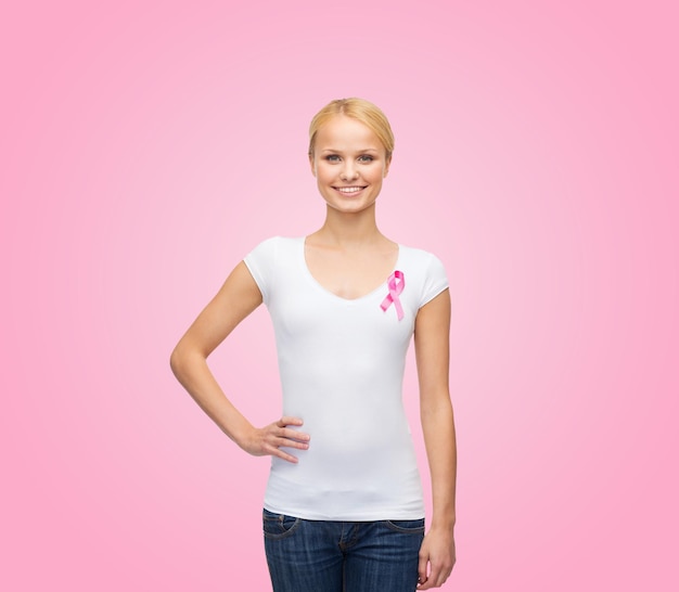 concetto di assistenza sanitaria, medicina e cancro al seno - donna in maglietta bianca con nastro rosa per il cancro