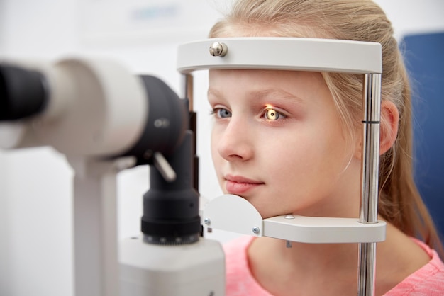 concetto di assistenza sanitaria, medicina, persone, vista e tecnologia - ragazza che controlla la vista con il tonometro presso la clinica oculistica