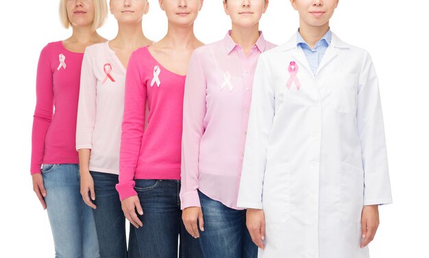 concetto di assistenza sanitaria, persone e medicina - primo piano di donne in camicie bianche con nastri rosa per la consapevolezza del cancro al seno su sfondo bianco