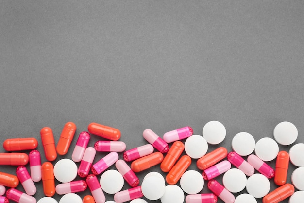 Concetto di assistenza sanitaria Pillole colorate su sfondo grigio