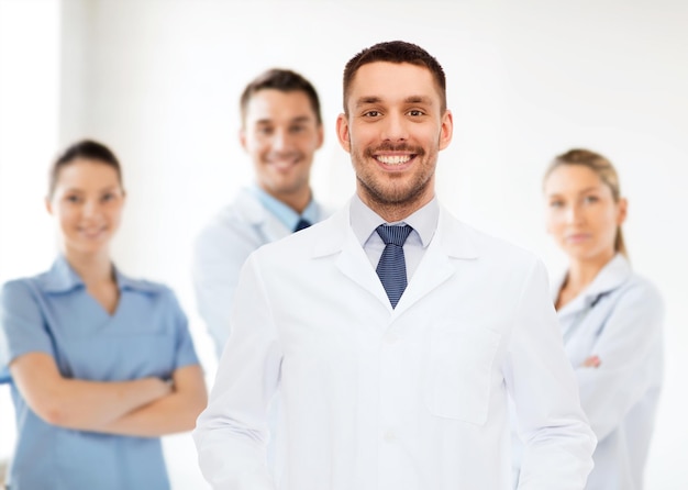 concetto di assistenza sanitaria, professione e medicina - medico maschio sorridente in camice bianco su sfondo bianco