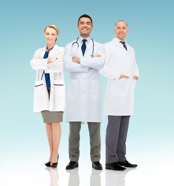 concetto di assistenza sanitaria, pubblicità, persone e medicina - gruppo di medici sorridenti in camice bianco su sfondo blu