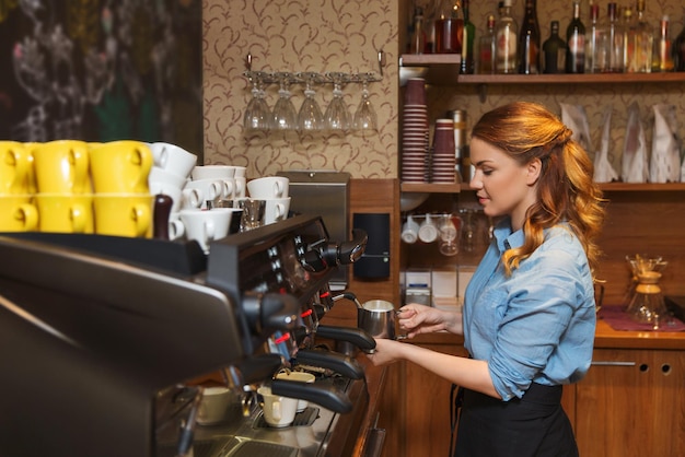 concetto di attrezzature, caffetteria, persone e tecnologia - donna barista che fa il caffè con la macchina al bar caffetteria o alla cucina del ristorante