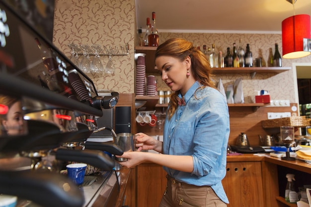 concetto di attrezzature, caffetteria, persone e tecnologia - donna barista che fa il caffè con la macchina al bar caffetteria o alla cucina del ristorante