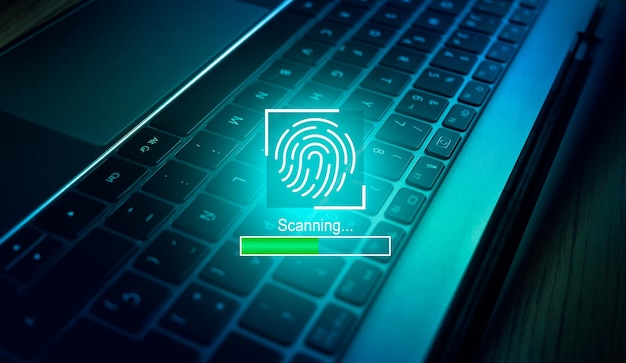 Concetto di autenticazione biometrica. scansione delle impronte digitali con la tastiera del laptop come sfondo.