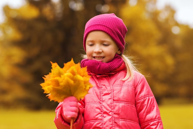 concetto di autunno, infanzia, felicità e persone - bella bambina felice con il mazzo di foglie d'acero all'aperto