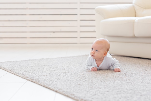 Concetto di bambino, infanzia e neonato - Bel bambino si trova sul pavimento.