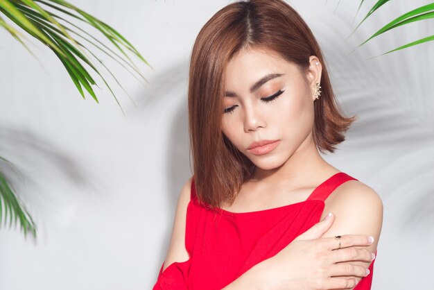 Concetto di bellezza estiva. Ritratto di giovane donna asiatica in abito rosso