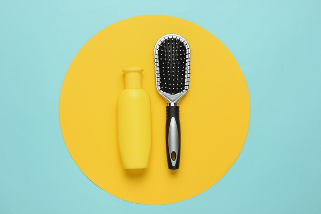 Concetto di bellezza minimalista Cura dei capelli Pettine e bottiglia di shampoo