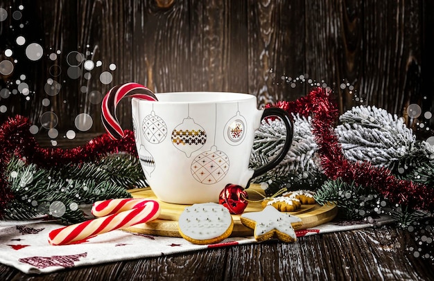 Concetto di Buon Natale Tazza bianca con ornamento di Natale con biscotti lecca-lecca Palle di Natale