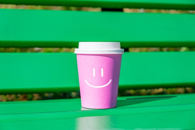 Concetto di buon umore e positivo con faccina sorridente su una tazza di caffè usa e getta